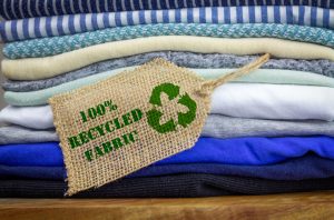 Återvinna klädikonen på tygetiketten med 100 procent återvunnen text, återanvändning av konceptillustrationer, återvinna kläder och textilier för att minska avfall